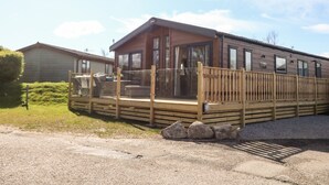 A mobile home with a wooden deck and a covered porch. - Curlew Lodge (Carnforth)