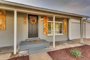 Stunning home with a grey brick facade, white trim, and chevron-patterned windows.