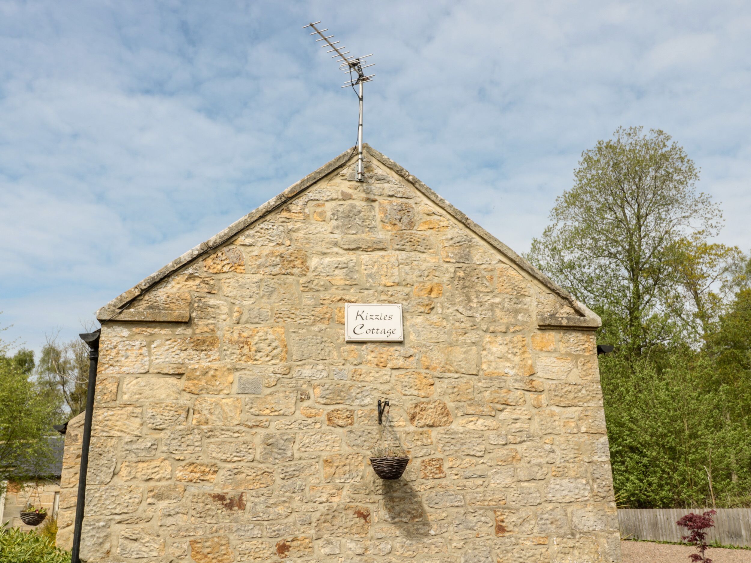 A stone building with a sign reading 'Kizies Cottage.'