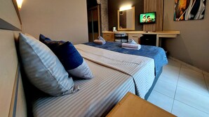 A hotel room with two beds, a desk, a television, and a painting on the wall. - Summer Rose Hotel (Manavgat)