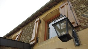 Un edificio de piedra con una ventana y un farol.