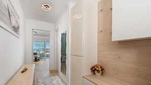 A modern kitchen with a wooden countertop, a built-in oven, and a view of the city through a large window. - Premium Apartment Panoramico – Spacious 4-Star Holiday Apartment with a Sea view (Krk)