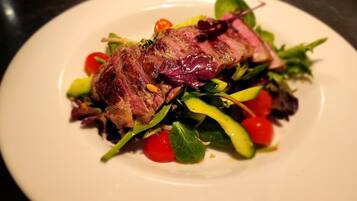 A plate with a grilled steak and a mixed green salad.