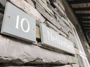 En stenvæg med to skilte: et med tallet '10' og et andet med ordet 'Netherst'.