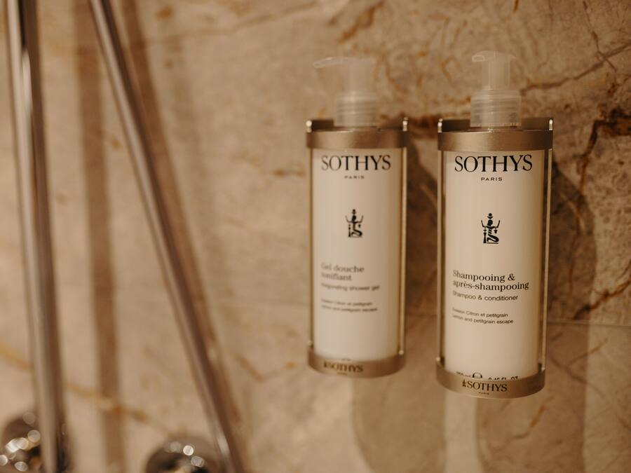 Två flaskor av Sothys Paris duschgel och schampo placerade på en marmoryta.
