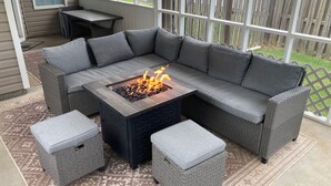 A sectional sofa with a built-in fire pit, two ottomans, and a small table on a patterned rug. - Bright centrally located 3 bed/2 bath with fenced private yard (Aiken)