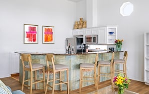 Una cocina moderna con barra, muebles blancos y salpicadero de azulejos.