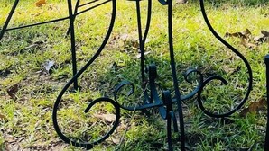 Ein eingeschossiges Gebäude mit flachem Dach und einer Reihe von Fenstern. Vor dem Gebäude steht ein runder Metalltisch mit einem Stuhl.