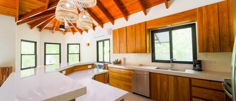 Een koelkast, een kookplaat, kookgerei, borden en bestek