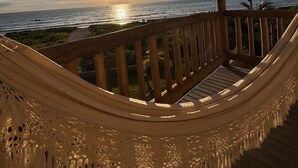 A hammock under a wooden pergola with a view of the sunset over the ocean. - Condominio Praias de Maragogi (Maragogi)