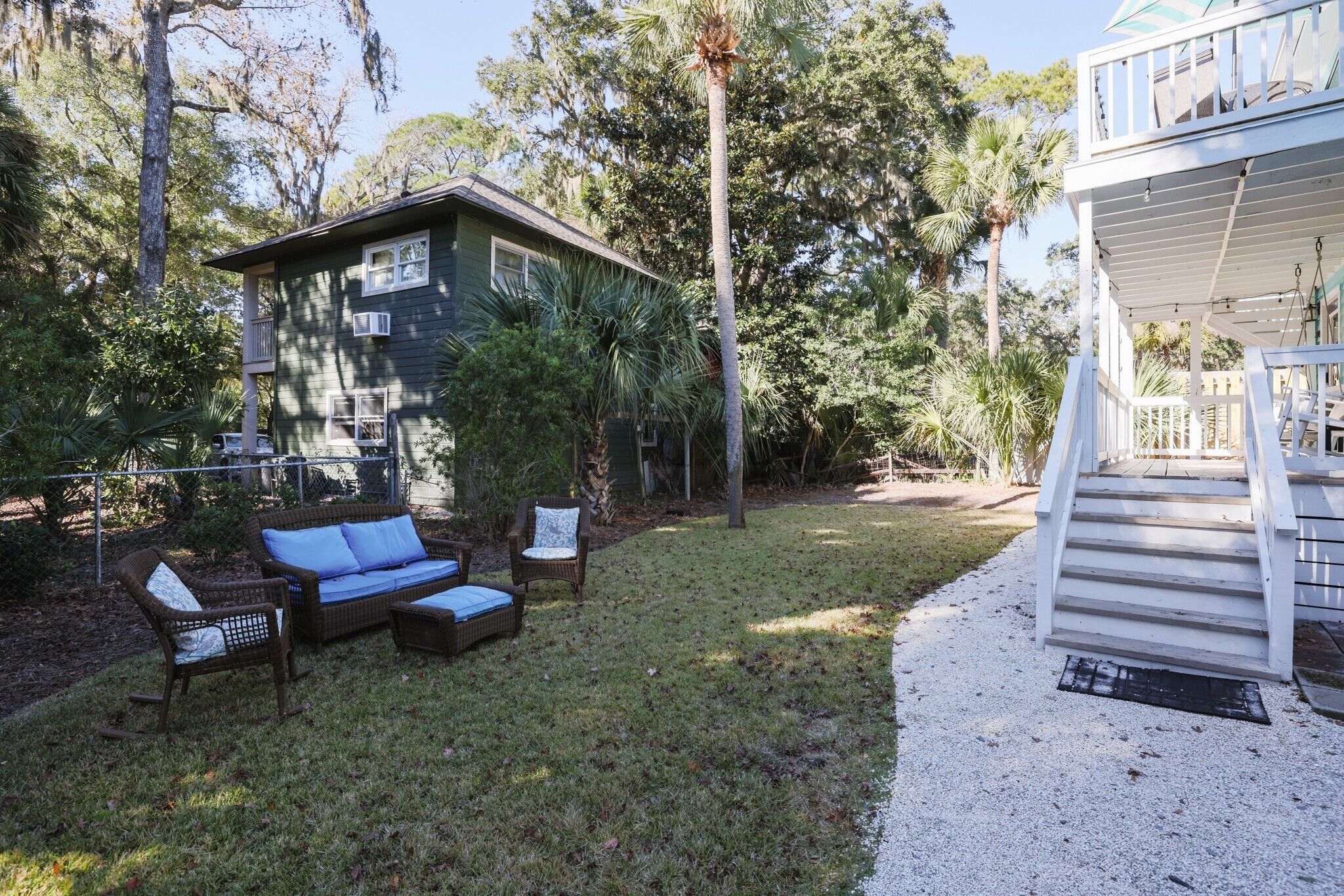 A house with a covered porch, a lawn, and outdoor furniture.