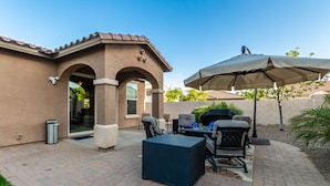 A patio with outdoor furniture, a grill, and a large umbrella. - Gorgeous 3/2 Corner Lot with Firepit and Grassy Yard! (Gilbert)