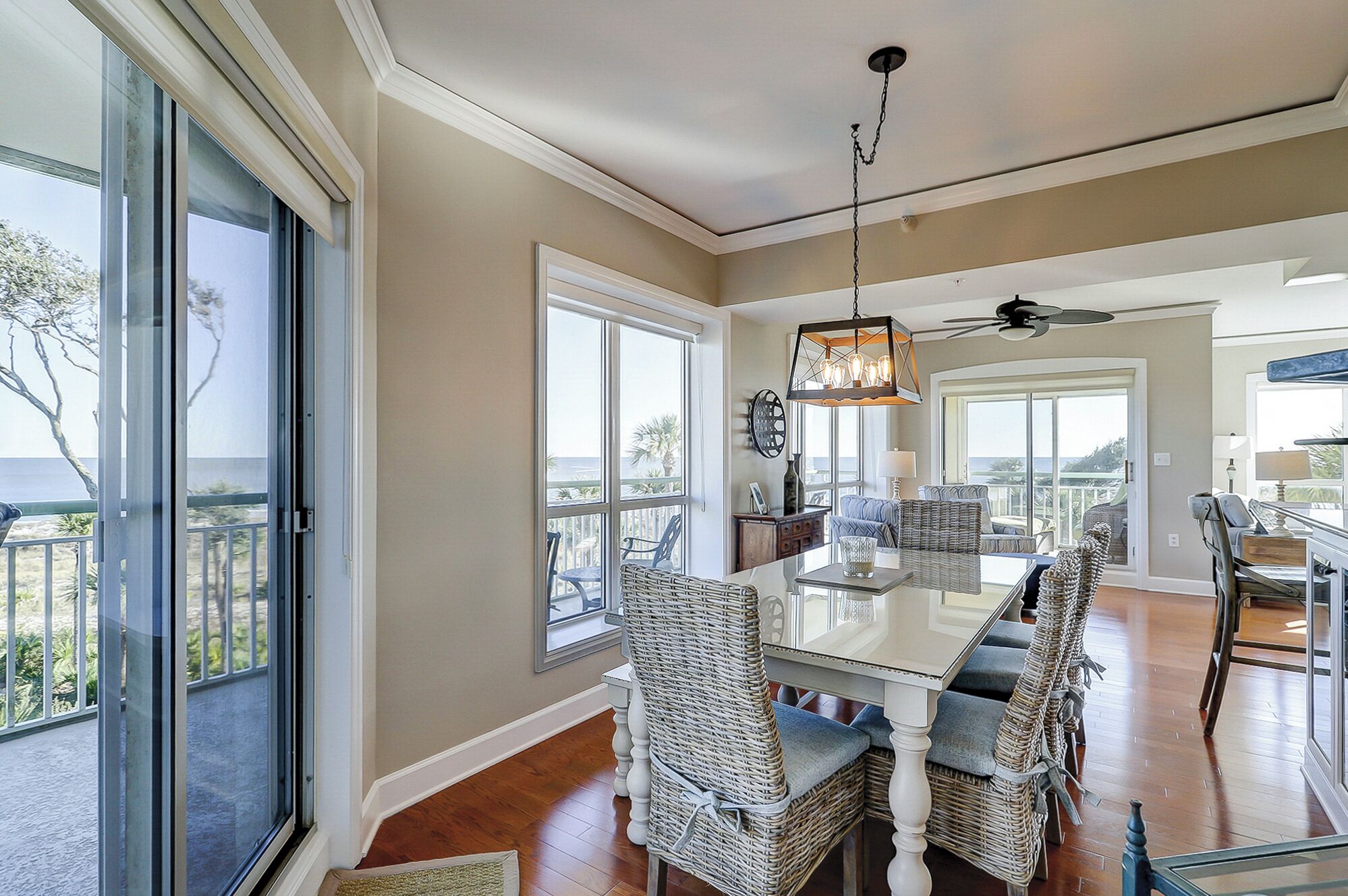 A spacious dining area with a high ceiling, large windows, and a view of the outdoors.
