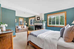 Relax in this inviting bedroom with a large bed, cozy seating area, and fireplace.
