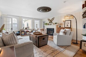 Relax in a cozy living room with a comfortable seating area, fireplace, and plush rug.