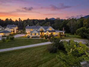 A residential area with multiple houses, well-maintained lawns, and a clear sky. - Lucy Queen Suite in Main House - Red Clover Inn (Mendon)