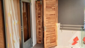 Un interior moderno con una puerta de madera, una puerta de cristal y suelo de baldosas.