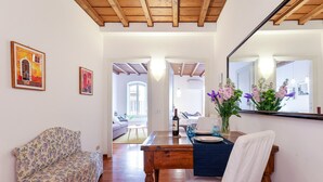 Un coin repas avec une table en bois, des chaises et un miroir.