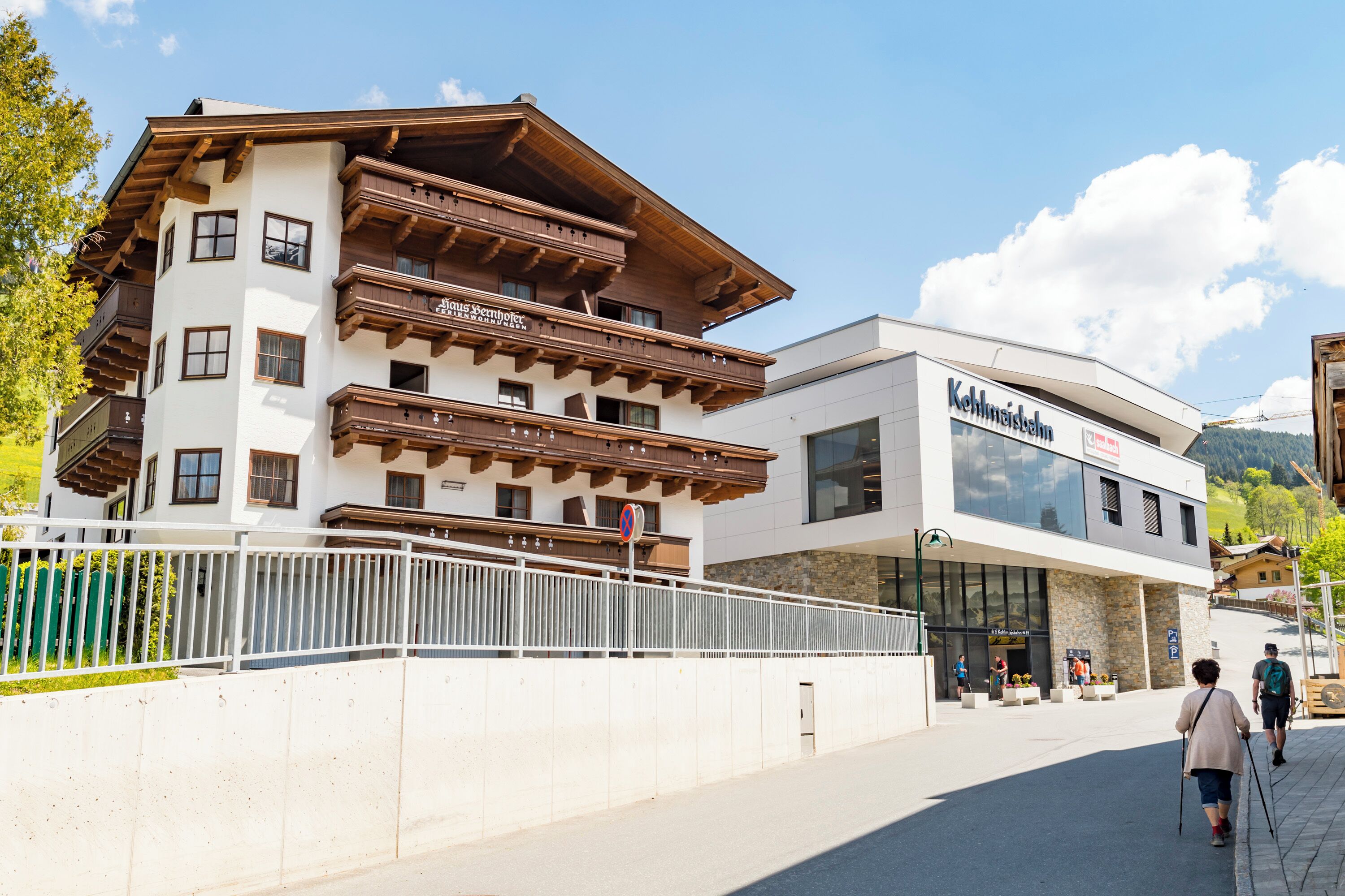 A hotel with a traditional Alpine architectural style, featuring wooden balconies and a modern entrance.