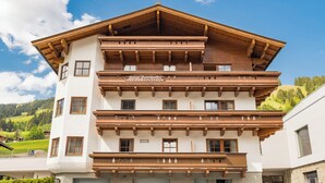 A multi-story hotel with wooden balconies and a sign indicating it is a guesthouse. - Appartements Bernhofer  (Saalbach-Hinterglemm)