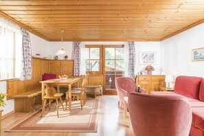 A cozy room with wooden furniture, a dining area, and a sofa. - Appartements Bernhofer  (Saalbach-Hinterglemm)