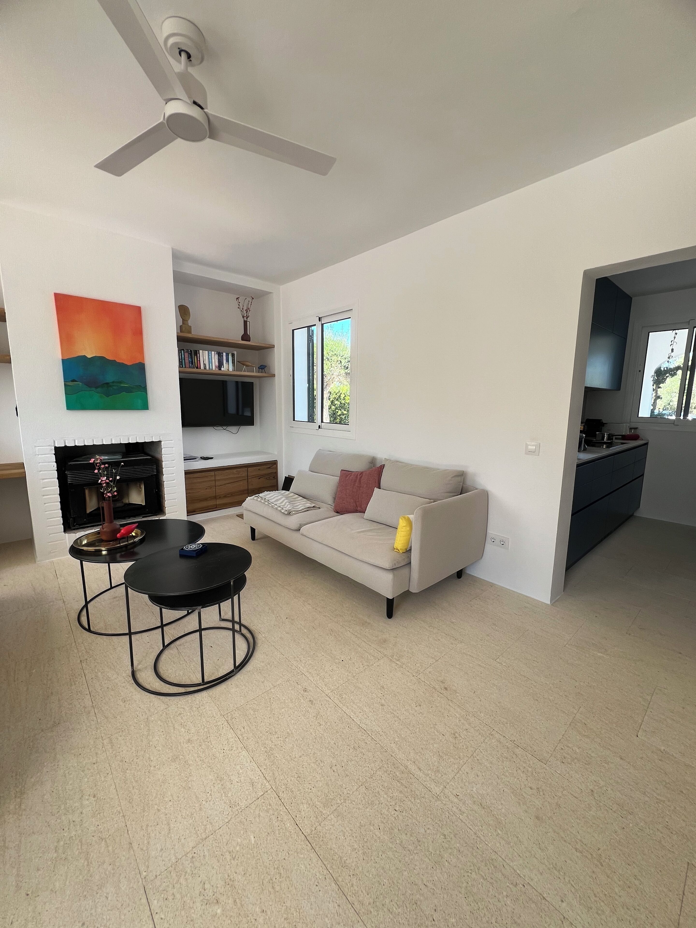 Un salon moderne avec un canapé, une table basse et une cheminée.