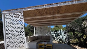 An outdoor seating area with a wooden pergola, a white lattice partition, and a beige sofa. - Fantastic Villa in Binixica,  pool, A/C, close to beaches (Binixiquer)