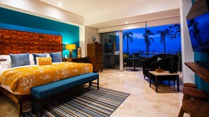 A modern bedroom with a large bed, a ceiling fan, and a balcony with a view of palm trees and the city skyline. - Fully remodeled 12 stories up! First floor retreat!! (Puerto Vallarta)