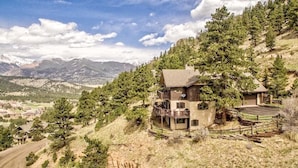 A two-story mountain lodge with a balcony, surrounded by trees and mountains. - Destiny Vacation Home At Windcliff 3 Bedroom Home by RedAwning (Estes Park)