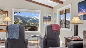 A room with two leather recliners, a small table, and a window with a mountain view. - Destiny Vacation Home At Windcliff 3 Bedroom Home by RedAwning (Estes Park)