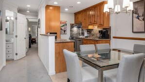 Una cocina moderna con armarios de madera, una mesa de comedor de vidrio y una isla central.