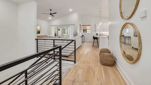 A modern interior with a staircase, a kitchen area, and a dining space.