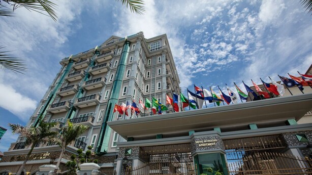 A multi-story building with a balcony displaying numerous flags. - Heng Mohasal Apartment (Phnom Penh)