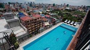 A rooftop swimming pool with dolphins, surrounded by a cityscape. - Heng Mohasal Apartment (Phnom Penh)
