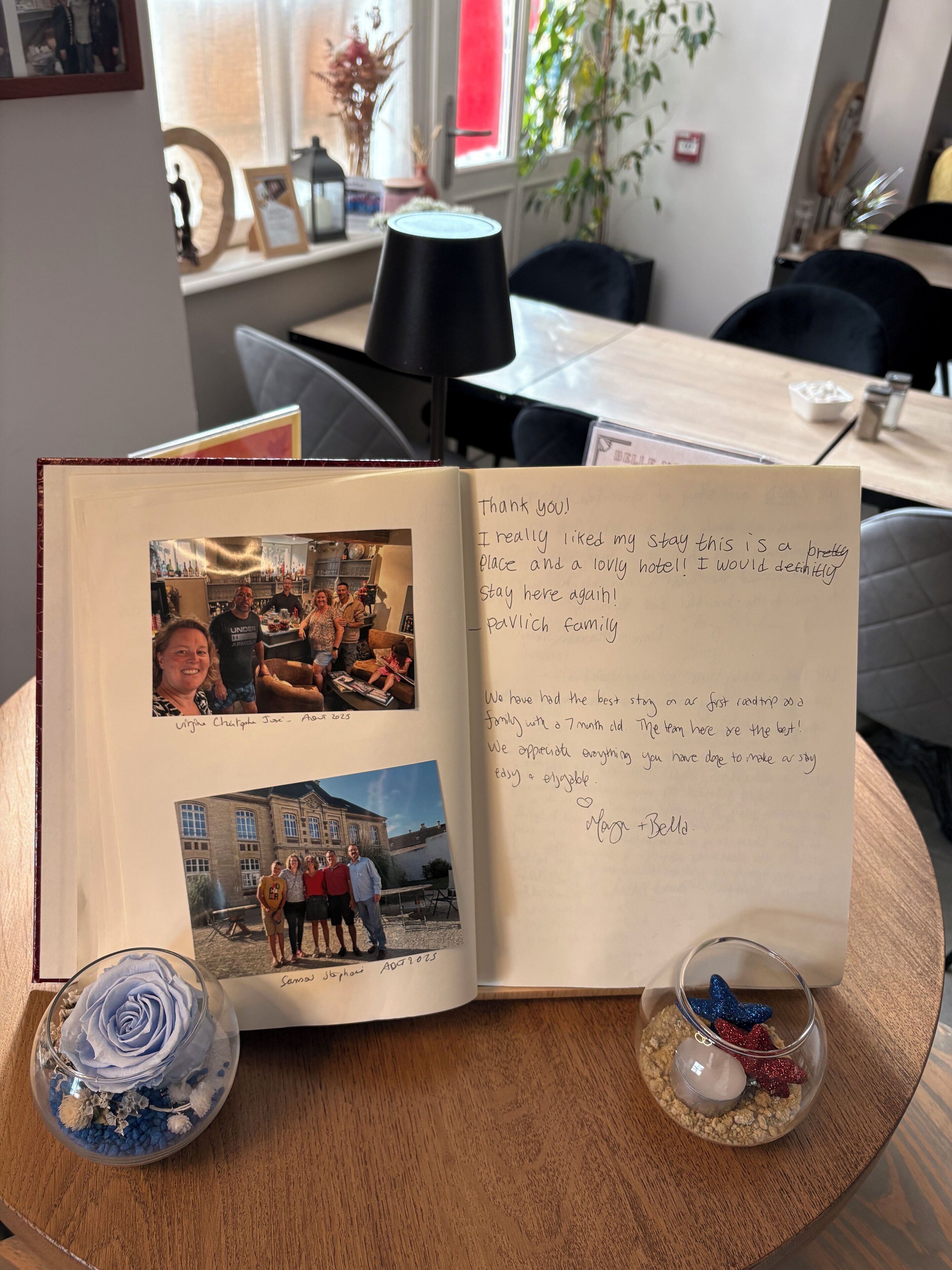 An open guestbook with handwritten notes and photos.