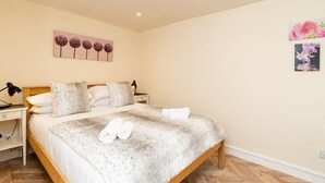 A bedroom with a bed, bedside tables, and a wall-mounted artwork. - Lovely 1 bed apartment with free parking - Pass the Keys (Bath)