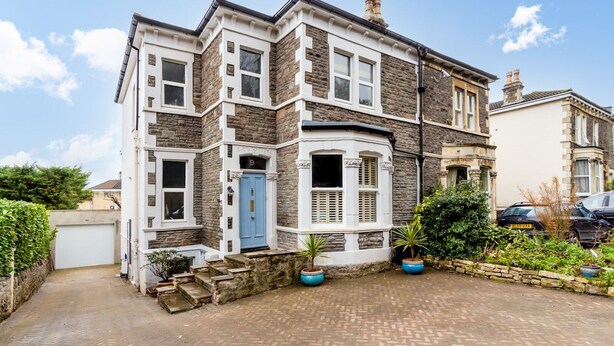 A two-story house with a stone facade, a blue door, and a brick driveway. - Lovely 1 bed apartment with free parking - Pass the Keys (Bath)