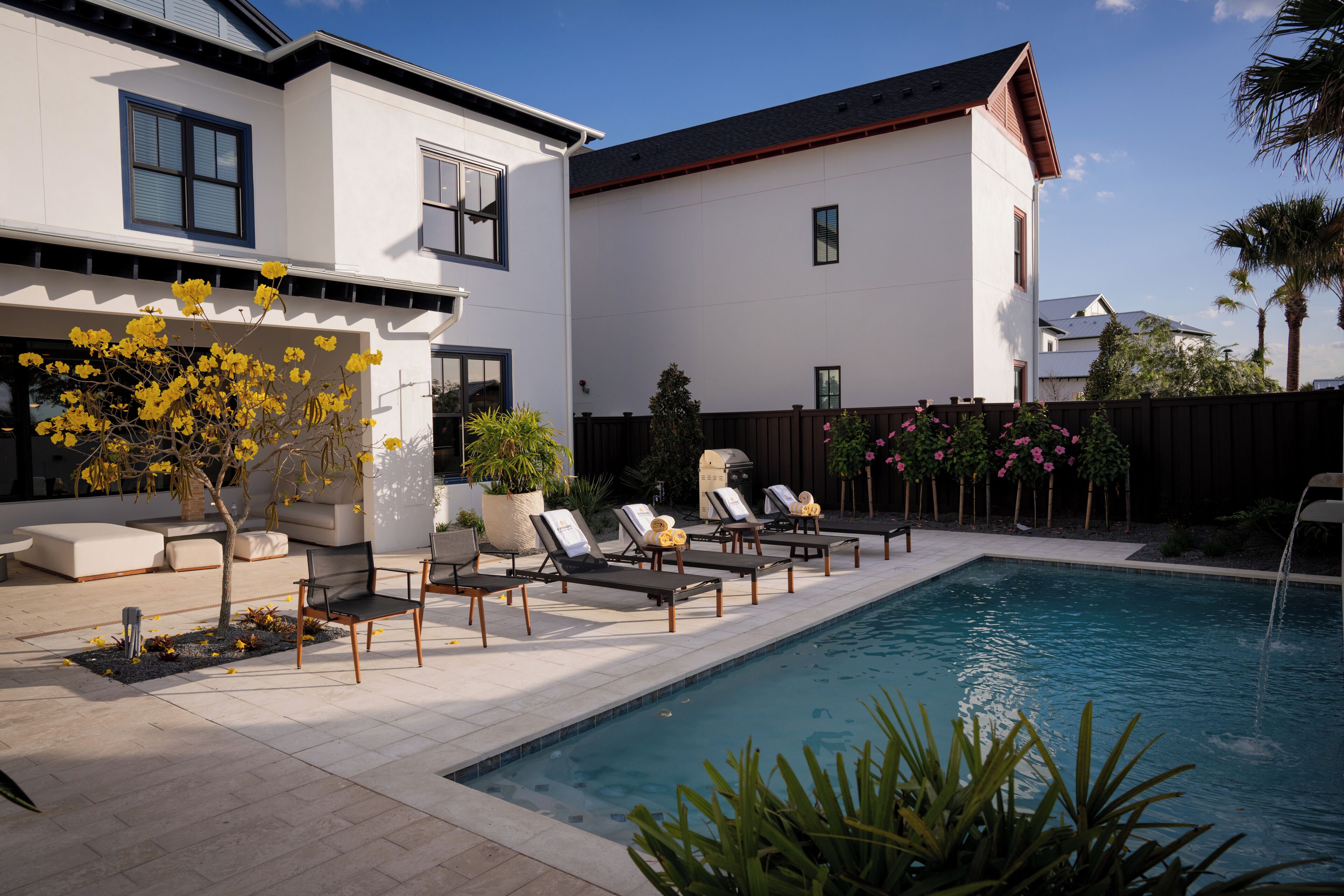 Une maison moderne dotée d’une piscine, d’un espace extérieur aménagé et d’un jardin clos.