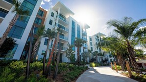 A modern multi-story hotel with balconies, palm trees, and a clear sky. - Evermore Orlando Resort (Orlando)
