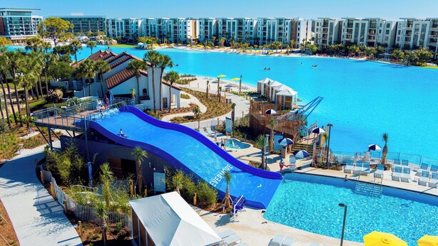 A resort with a large pool, a water slide, and a beach area. - Evermore Orlando Resort (Orlando)