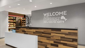 A reception desk with a 'Welcome to the Friendly Seaway City' sign, a snack bar, and a 'Hilton' sign. - Hampton Inn By Hilton Cornwall (Cornwall)