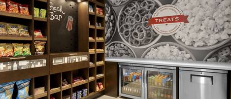 A snack bar with shelves stocked with various snacks and a refrigerated display case.