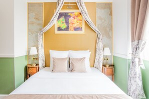 A bed with a canopy, two bedside tables with lamps, and a painting on the wall. - Merveil - Luxury Suite - Notre-Dame - Saint Louis (Paris)