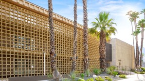 Un edificio con fachada de entramado y palmeras al frente.