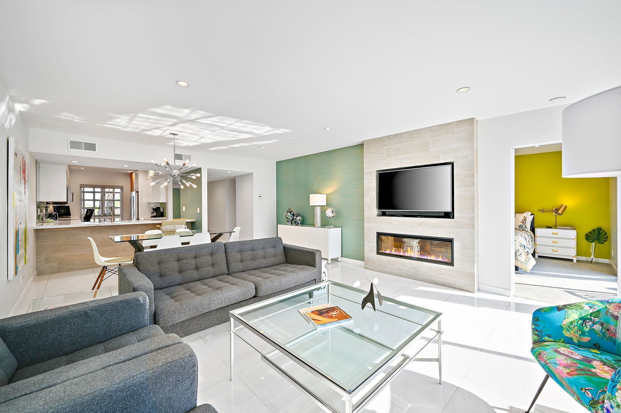 A modern living room with a sofa, coffee table, and a flat-screen TV mounted on the wall.