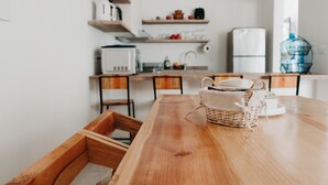 Une cuisine moderne avec des meubles en bois, un réfrigérateur blanc et un distributeur d’eau.