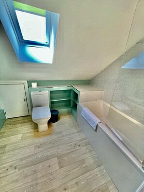 Une petite salle de bain comprenant des toilettes, un lavabo et une baignoire.