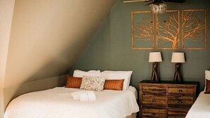 Una camera da letto con un letto, una cassettiera e due lampade a parete.
