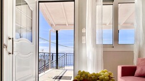 A room with a marble floor, a pink sofa, and a bowl of fruit on a table. - Nissaki Anemone Luxury Apartment with Jacuzzi (Nissaki)