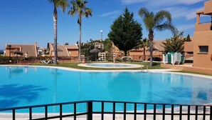 Una piscina con palmeras y un cielo azul despejado.